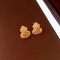 Vista macro de pendientes bañados en oro con forma de calabaza, cristales y circonitas - Pin de Plata - Dorado - Café Claro