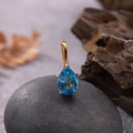 Detail of S925 silver gold-plated pendant with teardrop blue gemstone on natural rocks - Natural Topaz Water Drop Pendant Gold