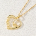Macro detail of gold Claddagh heart pendant with Mom engraving and white zircon inlay - Gold Heart Mom/Claddagh Crown Heart