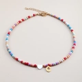 Detail of colorful beaded necklace with white heart charm and golden letter C pendant - Letter C