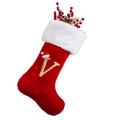 Detail of red plush Christmas stocking with white faux fur trim and gold letter V embroidery - Letter V