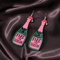 Detail of green glitter champagne bottle earrings with Fizz The Season text on silk - Green & Pink Bottle (Silver Hook)