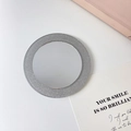 Tragbarer runder Kosmetikspiegel mit silbernem Glitzer-Finish auf weißem Hintergrund - Spiegel-Grau / Ca. 6,6 cm