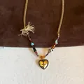 Detail of vintage heart pendant necklace with tiger eye beads and cream fringe tassel - Gold Heart Cross Star Tassel (34#)