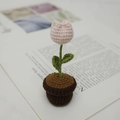 Handmade crochet pink tulip flower in a brown knitted pot on an open book - Pink Tulip Pot