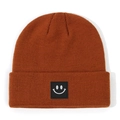 Caramel knitted beanie for babies featuring a cute black square smiley face patch - Size S (0-2Y) / Caramel Orange