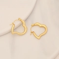 Dettaglio macro di orecchini a cerchio a cuore dorati lucidi su un vassoio di ceramica - Stile Cerchio a Forma di Cuore(11#)