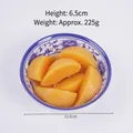 Postre de durazno artificial realista en un bol de porcelana tradicional azul y blanco - Trozos de Melocotón Amarillo