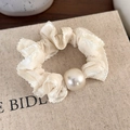 Close-up of elegant cream polka dot scrunchie with lace edge and large pearl detail - Cream White Solid