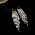 Dettaglio di orecchini lunghi a frangia placcati oro 18 carati con eleganti perle bianche - Fermaglio Per Orecchio Con Nappa Di Perle Argentate / Argento