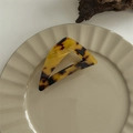 Detail view of large tortoiseshell pattern hair claw clip on decorative ceramic plate - Oblique Triangle