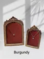 Detail of necklaces displayed on a wine red vintage frame with gold relief - Burgundy
