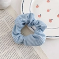 Lichtblauwe wafelgebreide scrunchie haarelastiek op een decoratieve krantenachtergrond - 7# Hemelsblauw