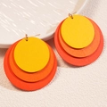 Close-up of triple layered geometric wooden earrings with yellow orange red gradient - Orange Gradient
