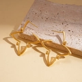 Detailed view of 18K gold plated star earrings with zircon on a natural stone base - Gold