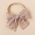 Detail of baby nylon headband featuring a beige floral lace bow with delicate embroidery - Rose Pink