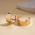 Detailansicht goldener, breiter C-Ohrringe mit poliertem Metall-Finish und glatter Oberfläche - Breite C-Form / Gold