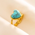 Detailed macro of gold twisted metal ring featuring a heart-shaped turquoise stone inlay - Gold-Light Blue Stone