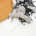 Detail view of a soft grey plush hair claw clip on white decorative background - Grey
