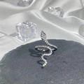 Macro shot of silver snake ring with crystals on black stone and white silk background - No.15 Black Open Ring