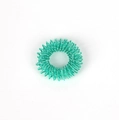 Close-up of a turquoise metallic spring massage ring for finger acupressure and stress relief - Green