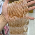 Faceted light orange and transparent natural stone beads held in hand for jewelry DIY - Gradient Citrine 3mm