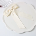 Cream satin double bow hair clip with elegant long tails on a white lace plate - Creamy White