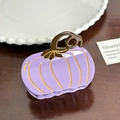 Purple pumpkin-shaped acetate hair claw clip with golden accents on dark wood background - Purple Pumpkin