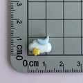 Dettaglio del mini ciondolo a nuvola in resina con luna e stelle su un righello graduato - Nuvola con Luna Blu e Stella Gialla