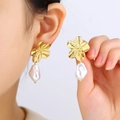 Elegant gold flower earrings with baroque pearls shown on model and held in hand - Gold Flower Pearl Dangle Earrings