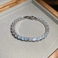 Detailansicht eines silbernen Tennisarmbands mit Zirkonia-Steinen in einer Schmuckschatulle - Silber-Weiß
