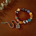 Detail of ethnic beaded bracelet with turquoise, agate, yak bone beads and metal pendant - Style D: Single Tiger Tooth Dzi Bracelet