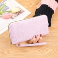 Long lavender zipper wallet for women featuring elegant floral embossing and a wrist strap - Light Purple