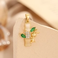 Macro view of a bamboo and rabbit pendant with opal stones and green crystals - Gold Cat's Eye Bamboo Rabbit