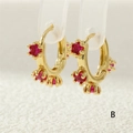 Macro detail of 18K gold plated hoop earrings with three faceted red zircon stones - Red Gemstone Style (ER0748-B)