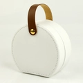 White cylindrical travel jewelry box with brown leather handle and gold rivet detail - PU Leather / Round Handheld Style / Handheld White