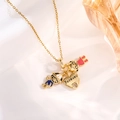 Macro shot of gold necklace featuring boy, girl, and heart charms on white fabric - Gold Couple Heart Style