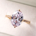Macro shot of large oval-cut pink zircon ring with claw setting and pave band - US 9 / Gold