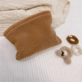 Detail of warm brown sherpa makeup bag with matching fluffy hair scrunchies on white fabric - Camel
