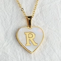 Golden heart necklace with letter R shell inlay on soft white textured fabric - Letter R / Gold