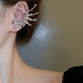 Close-up of sparkling colorful zircon ear cuff showing luxury wing-shaped design on model - Earpiece - Colored (left Ear)