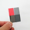 Close-up of hand holding four colorful miniature books in a plastic pack for 1:12 dollhouses - Black