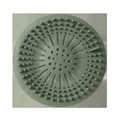 Filtro per lavandino circolare in silicone verde con fori ferma-capelli su sfondo bianco - Verde Tondo Potenziato