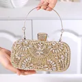 Detail der goldenen Abendtasche mit floralem Strassmuster und rundem Metallgriff - Gold