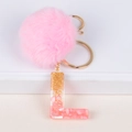 Pink fur pompom keychain with golden letter L resin pendant and glitter accents - Letter L