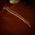 Dettaglio di ear cuff dorato con frange su velluto rosso con elegante design a nappa - Polsino per Orecchie con Frange Oro