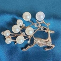 Close-up of rose gold reindeer brooch with white pearls and sparkling rhinestones - Pearl Elk Brooch