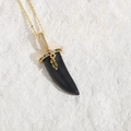 Luxurious bohemian black horn pendant necklace with colorful gemstones on a white rock - Black