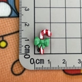 Macro shot of miniature candy cane resin accessory with ruler showing 1.5cm size detail - Candy Cane