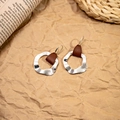 Detail of silver wavy earrings with brown leather accents on a textured backdrop - Silver Irregular Wave Leather